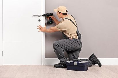Locksmith installing a lock on a door